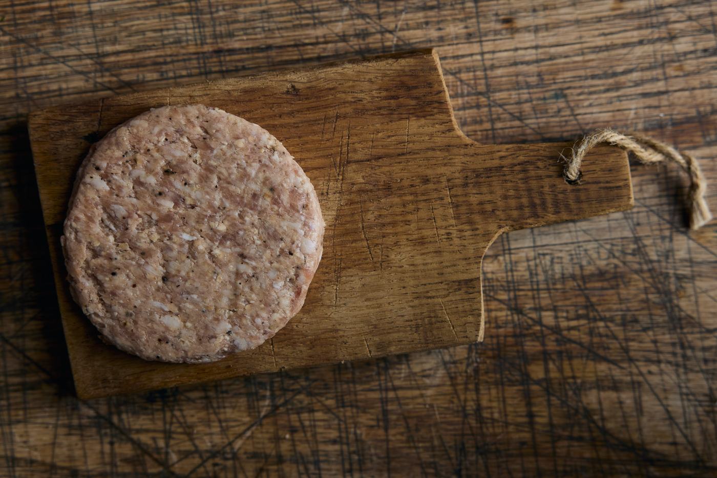 Four hand-pressed pork burger patties stacked