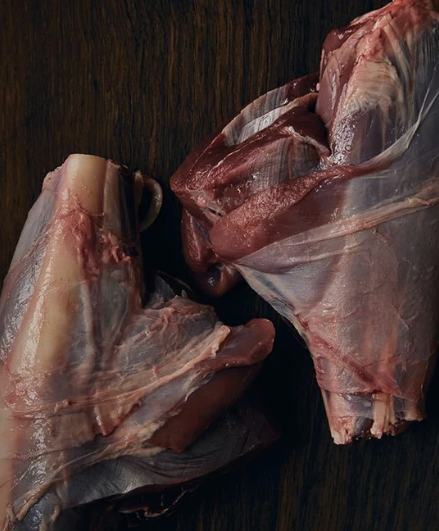 Two wild venison shanks on dark wood