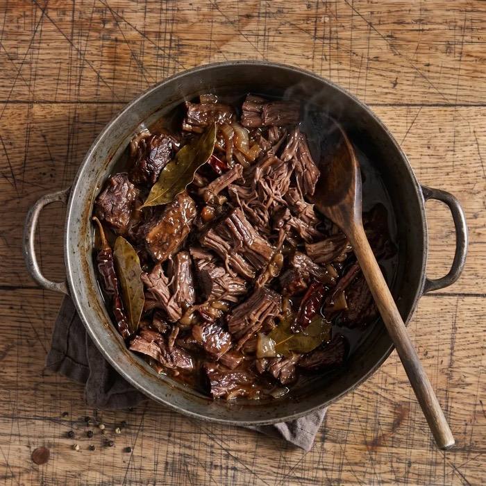 Rustic pre-cooked Beef Barbacoa in a cooking pot